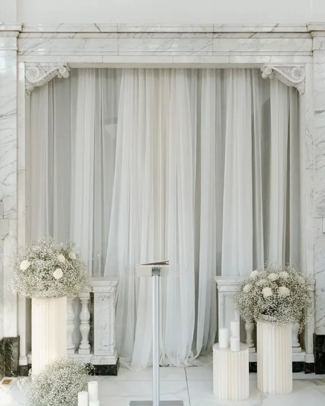 The beauty of a clean canvas is how it allows texture to take center stage🕊️

We are seeing a beautiful shift toward minimalist, airy draping and the ethereal, cloud-like volume of baby's breath. Paired with soft candlelight and crisp white linens, the result is a ceremony space that feels both grounded in history and remarkably modern.

Venue: @citizensballroom @fetewell
Photography: @joshuabinghamphoto
Hair & Makeup: @meganwiththegoodhair for @jkwbeauty
Dress: @antoniogual
Lashes: @blink.lashes
Nails: @phuong.nailedit